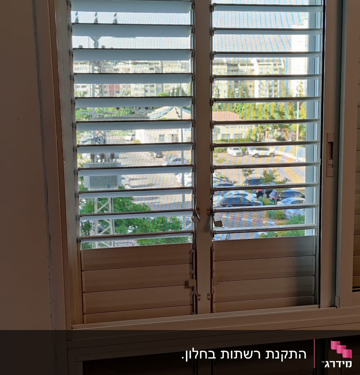 חלון עם תריסי אלומיניום פתוחים למחצה